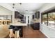 A modern kitchen with dark wood cabinets, a breakfast bar, and a pass-through window to the backyard at 26 Morningside Dr, Wheat Ridge, CO 80215