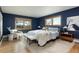 Spacious main bedroom with blue walls, three windows, a plush rug, and wood floors at 26 Morningside Dr, Wheat Ridge, CO 80215