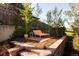 A stone terrace in the backyard has a lounger, small side table and a potted plant at 26 Morningside Dr, Wheat Ridge, CO 80215