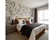 Stylish bedroom features a comfortable bed, accent wall design, bedside tables, and ample natural light at 6153 N Ceylon St # 205, Denver, CO 80249