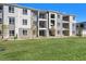 Modern apartment building with manicured lawn, young trees, and balconies, offering stylish and comfortable living at 6153 N Ceylon St # 205, Denver, CO 80249