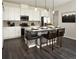 Bright kitchen features white cabinets, stainless steel appliances, and a large center island with counter seating at 6153 N Ceylon St # 205, Denver, CO 80249