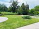 Expansive backyard with a circular patio area, mature trees, and lush green space at 8211 Rocky Mountain Dr, Lakewood, CO 80214
