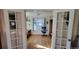 Bright home office showcasing hardwood floors, natural light, and glass paneled French doors at 8211 Rocky Mountain Dr, Lakewood, CO 80214