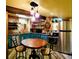 Charming kitchen highlighting brick walls, a round dining table, and stainless-steel appliances at 8211 Rocky Mountain Dr, Lakewood, CO 80214