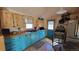 Charming kitchen featuring unique blue cabinets, wood countertops, and bright, natural lighting at 8211 Rocky Mountain Dr, Lakewood, CO 80214