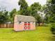 An inviting backyard shed with red doors and gray trim is a versatile space for storage or hobbies at 8211 Rocky Mountain Dr, Lakewood, CO 80214