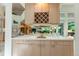 Stylish bar area with a mirrored backsplash, custom cabinetry, and ample counter space at 400 S Steele St # 13, Denver, CO 80209