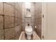 Cozy powder room featuring stone-look walls, a toilet, and modern artwork at 400 S Steele St # 13, Denver, CO 80209