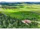 Serene property featuring a paved driveway winding through a forest to a large home with a 3-car garage at 15533 S Perry Park Rd, Palmer Lake, CO 80133