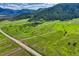 Expansive mountain view with a winding driveway leading up to a luxury home nestled among the trees at 15533 S Perry Park Rd, Palmer Lake, CO 80133