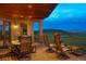 Exterior shot of the deck featuring wrought iron railing, chairs, table and mountain view at 15533 S Perry Park Rd, Palmer Lake, CO 80133