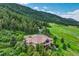 Beautiful home on a sprawling lot with a tile roof, surrounded by mature trees and landscaped gardens at 15533 S Perry Park Rd, Palmer Lake, CO 80133