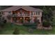 Back exterior of the home showcasing balcony, stone accents, and lush landscaping at 15533 S Perry Park Rd, Palmer Lake, CO 80133