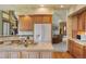 Open kitchen with wood cabinets, tile countertops, and a view to the living area at 15533 S Perry Park Rd, Palmer Lake, CO 80133