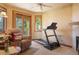 Inviting living room with a fireplace, a treadmill, and a sliding glass door to the outside at 15533 S Perry Park Rd, Palmer Lake, CO 80133