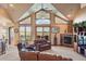 Cozy living room boasts high ceilings, large windows, stone fireplace and scenic views at 15533 S Perry Park Rd, Palmer Lake, CO 80133