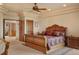 Spacious main bedroom with a ceiling fan, tray ceilings, and a luxurious wooden bed frame at 15533 S Perry Park Rd, Palmer Lake, CO 80133