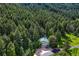 An outbuilding or shop nestled amongst towering pines offering an additional garage and extra space at 15533 S Perry Park Rd, Palmer Lake, CO 80133