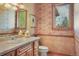 Charming powder room with floral wallpaper, tile accents, and a bright window view to the outside at 15533 S Perry Park Rd, Palmer Lake, CO 80133