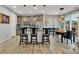Bright kitchen features an island with bar stools, stylish pendant lights, and stainless steel appliances at 25062 E Cedar Pl, Aurora, CO 80018