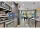 Well-lit kitchen featuring stainless steel appliances, granite counters, mosaic tile backsplash, and access to the dining area at 25062 E Cedar Pl, Aurora, CO 80018