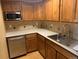 Efficient kitchen featuring stainless steel appliances, ample counter space, and warm wood cabinetry at 3872 S Dallas St # 7-107, Aurora, CO 80014
