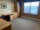 Well-lit office featuring built-in desk, storage cabinets, and a large window at 3872 S Dallas St # 7-107, Aurora, CO 80014