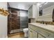 Bathroom featuring a walk-in shower with decorative stone work and a vanity with stone countertop at 27802 Shadow Mountain Dr, Conifer, CO 80433