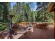 Spacious outdoor deck with comfortable seating, dining area, and heater, perfect for relaxing in the serene natural setting at 27802 Shadow Mountain Dr, Conifer, CO 80433