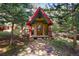 Quaint colorful cottage nestled among trees with stone pathway, perfect for a getaway at 27802 Shadow Mountain Dr, Conifer, CO 80433