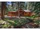 Charming log cabin home with a wrap-around porch and a serene creek running through the front yard at 27802 Shadow Mountain Dr, Conifer, CO 80433