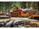 Lovely log home with a covered porch and a stream running alongside the property at 27802 Shadow Mountain Dr, Conifer, CO 80433