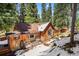 Side view of cozy cabin showing rustic wood siding, exterior bench, and windows at 27802 Shadow Mountain Dr, Conifer, CO 80433