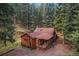 Charming cabin-style home featuring rustic wood siding, surrounded by lush greenery, offering a peaceful and private retreat at 27802 Shadow Mountain Dr, Conifer, CO 80433
