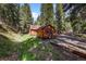 Charming cabin-style home with wood siding, surrounded by lush greenery, offering a peaceful and secluded retreat at 27802 Shadow Mountain Dr, Conifer, CO 80433