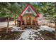 Charming cabin featuring unique architectural details, including a whimsical sunburst and decorative accents at 27802 Shadow Mountain Dr, Conifer, CO 80433