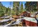 Outdoor hot tub near a wooden bridge and stream, surrounded by snowy woods at 27802 Shadow Mountain Dr, Conifer, CO 80433