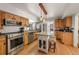 Bright kitchen with hardwood floors, center island with granite countertop, and stainless steel appliances at 27802 Shadow Mountain Dr, Conifer, CO 80433
