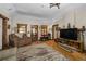 Warm living room featuring hardwood floors, a stone fireplace, and cozy seating at 27802 Shadow Mountain Dr, Conifer, CO 80433