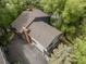 Aerial view of a home featuring a well-maintained roof, surrounded by lush trees and an expansive driveway at 4843 Silver Spruce Ln, Evergreen, CO 80439