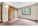 Bright bedroom featuring a window with a view of trees and double door closet at 4843 Silver Spruce Ln, Evergreen, CO 80439