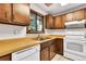 Kitchen with wooden cabinets and light countertops, equipped with a range, and a double basin stainless steel sink at 4843 Silver Spruce Ln, Evergreen, CO 80439