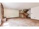 Bright living room featuring a stone fireplace, carpeted floors, and an open staircase at 4843 Silver Spruce Ln, Evergreen, CO 80439
