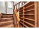 Carpeted staircase with wooden banister and built-in wooden shelves at 4843 Silver Spruce Ln, Evergreen, CO 80439