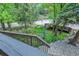 A tranquil view of the wooded backyard stream flowing under a brick bridge at 4843 Silver Spruce Ln, Evergreen, CO 80439