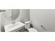 Clean powder room with pedestal sink, round mirror, and modern toilet at 21025 E 61St Dr, Aurora, CO 80019