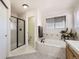 Well-lit bathroom featuring a soaking tub, separate shower, and a large window at 1525 E 133Rd Ave, Thornton, CO 80241