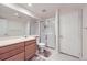 Bright bathroom featuring neutral colors, a glass shower stall, wood cabinets, and a modern sink at 1525 E 133Rd Ave, Thornton, CO 80241