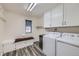 Well-lit laundry room featuring a washer and dryer, built-in storage with bench, and neutral paint tones at 1525 E 133Rd Ave, Thornton, CO 80241